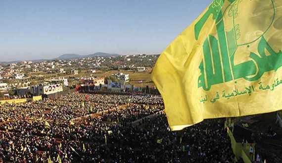 Supporters of Lebanon's Hezbollah leader Sayyed Hassan Nasrallah wave Hezbollah flags as they listen to him via a screen during a rally on the 7th anniversary of the end of Hezbollah's 2006 war with Israel, in Aita al-Shaab village