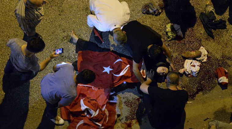 An injured woman draped in a Turkish flag is checked by others near military headquarters in Ankara